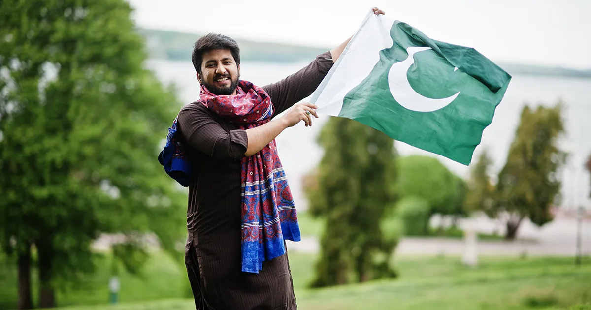 Jeune homme pakistanais tenant le drapeau du Pakistan.
