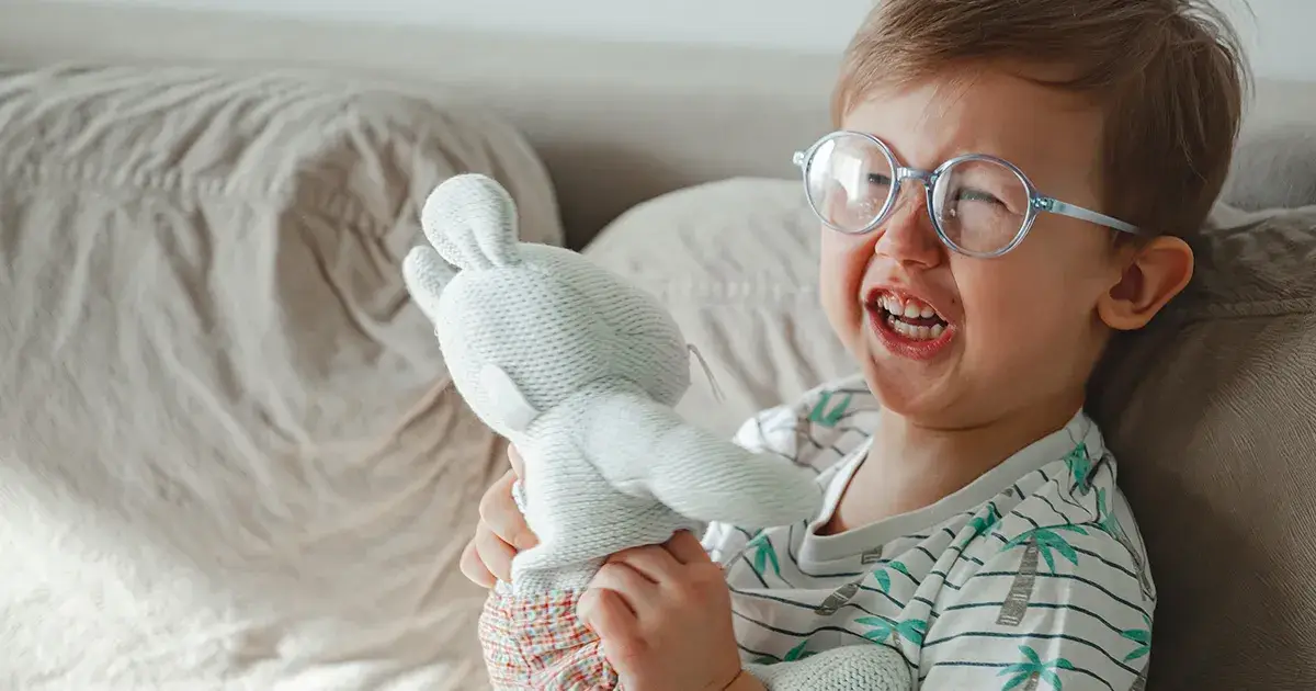 Enfant Autiste pleurant avec un doudou dans les mains